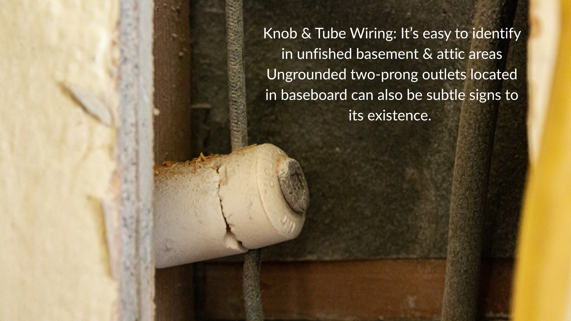 Knob and tube wiring in basement floor joists showing white ceramic knobs and dark single conductors